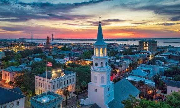 Sunset over historic church steeple and rooftops