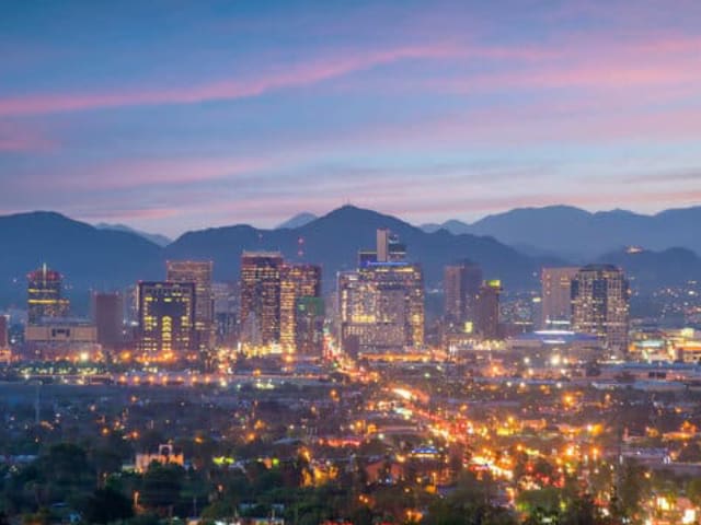 City skyline at dusk with mountains