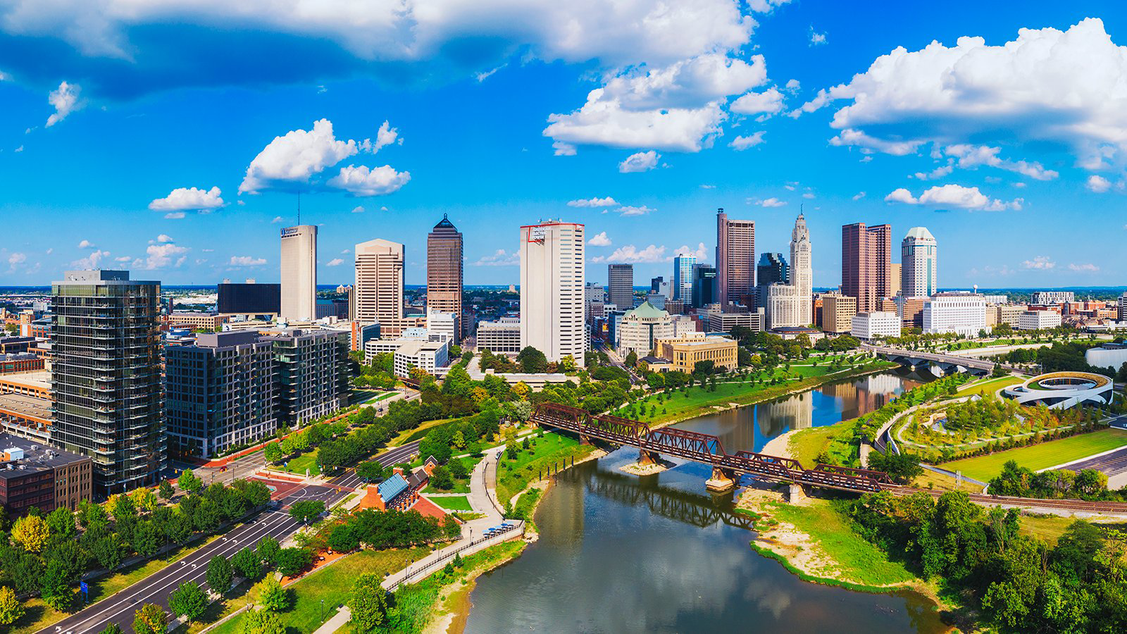 City skyline with river, bridges, and park